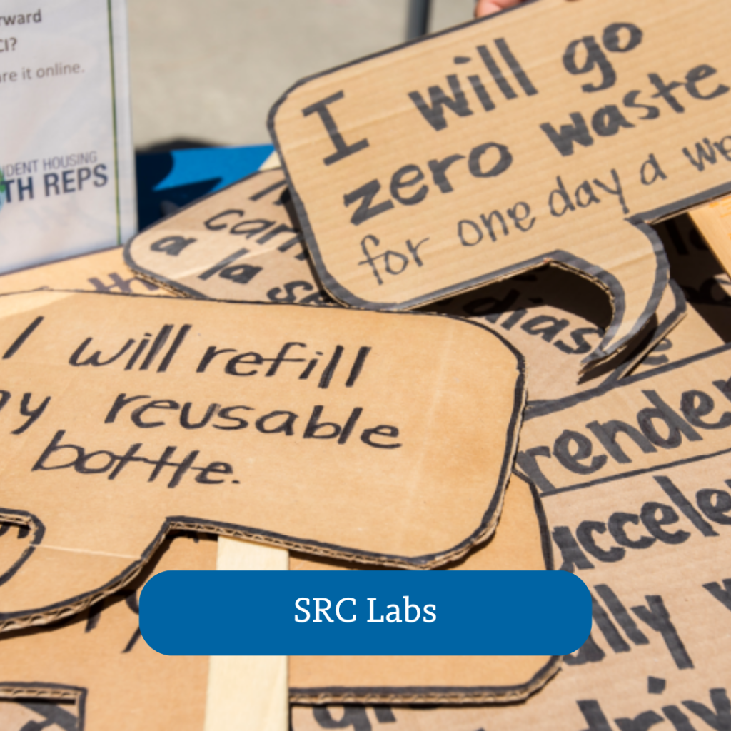 cardboard signs stacked on top of each other, SRC labs button overlayed onto the photo
